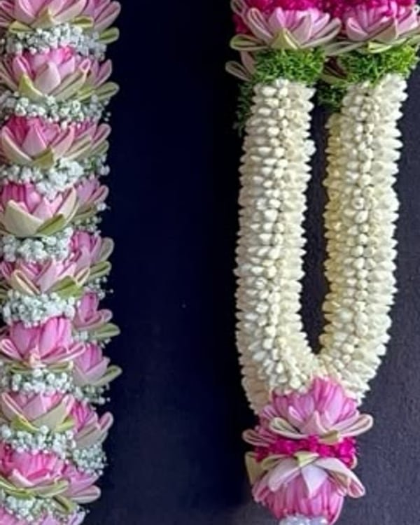 A row of lotus and jasmine garlands ready for delivery